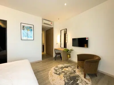 a room with a bed and a chair and a television at Corner Club Penang in George Town