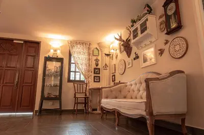 a living room with a couch and pictures on the wall at The Farmhouse in Ipoh