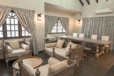 a living room with a table and chairs and windows at The Farmhouse in Ipoh