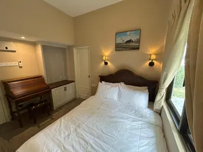 a bedroom with a white bed and a piano at The Farmhouse in Ipoh