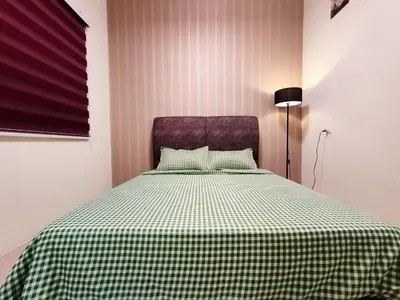 a bedroom with a bed with a green and white checkered blanket at Pavilionvillie M1T696 by irainbow in Ipoh
