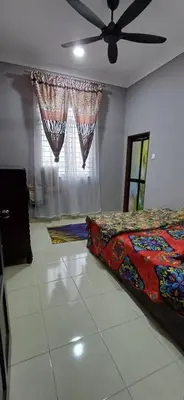 a bedroom with a bed and a ceiling fan at teratai ciknah in Penaga