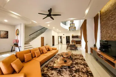 a living room with a couch and a ceiling fan at Zinnia Residence in Tanah Rata