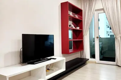 a living room with a flat screen tv on a wall at Modern Suite in Penang Island in Jelutong