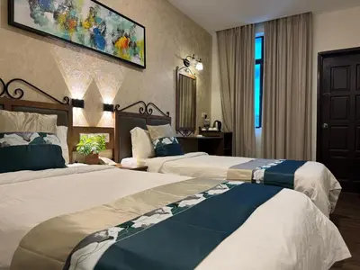 a hotel room with two beds and a mirror at K Garden Hotel (BS) in Bagan Serai