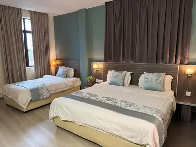 a hotel room with two beds and a window at K Garden Hotel (BS) in Bagan Serai