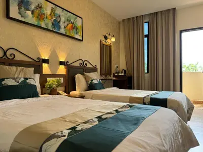a hotel room with two beds and a mirror at K Garden Hotel (BS) in Bagan Serai