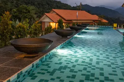 a row of bowls on the edge of a swimming pool at Sebayu Retreat Gopeng in Gopeng