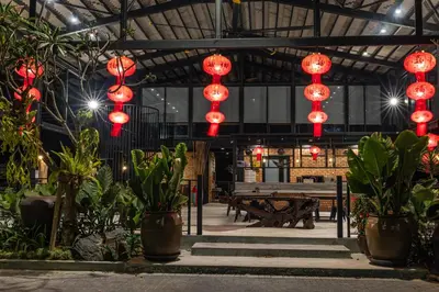 a building with red lanterns and benches and plants at Sebayu Retreat Gopeng in Gopeng