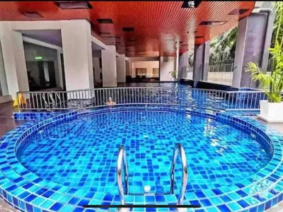 a large pool in a hotel with two people in it at The Ximplicity @ Venus Residence Sitiawan Manjung in Sitiawan