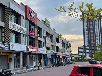 a row of buildings on a city street with cars at The Ximplicity @ Venus Residence Sitiawan Manjung in Sitiawan