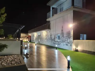 a building with a mural on the side of it at night at The Ximplicity @ Venus Residence Sitiawan Manjung in Sitiawan