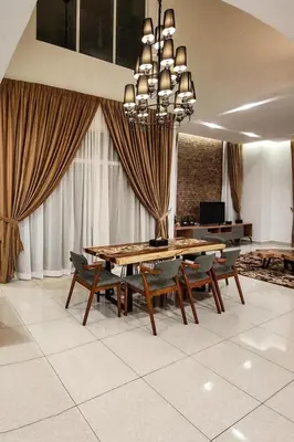 a dining room with a table and chairs and a chandelier at ZINNIA RESIDENCE in Tanah Rata