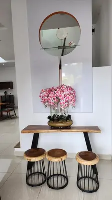 a table with a mirror and three stools at ZINNIA RESIDENCE in Tanah Rata