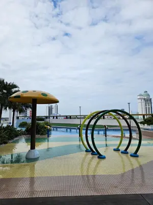 a slide in a pool with an umbrella at Metropol Serviced Apartment Bukit Mertajam Perda in Bukit Mertajam