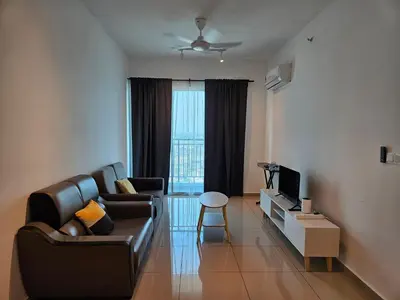 a living room with a couch and a television at Metropol Serviced Apartment Bukit Mertajam Perda in Bukit Mertajam
