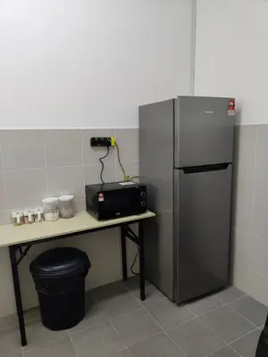 a kitchen with a counter and a refrigerator at ALEESYA Homestay at Emerald Avenue Brinchang in Brinchang