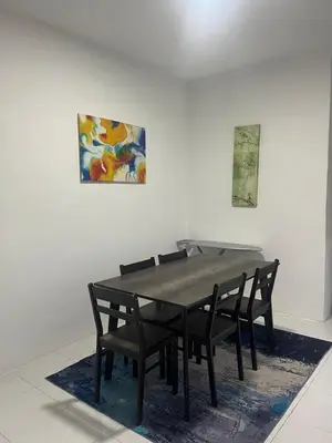 a dining room table with chairs and a painting on the wall at ALEESYA Homestay at Emerald Avenue Brinchang in Brinchang