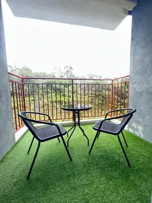 a patio with two chairs and a table on a balcony at ALEESYA Homestay at Emerald Avenue Brinchang in Brinchang