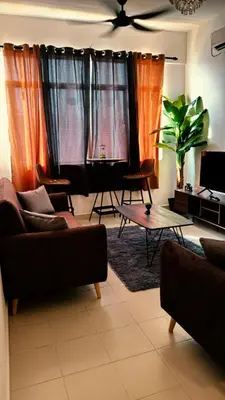 a living room with orange curtains and a couch at Prima Falim in Ipoh