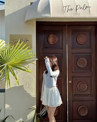 a young girl standing in front of a wooden door at The Palm Suite Tanjung Tokong in George Town