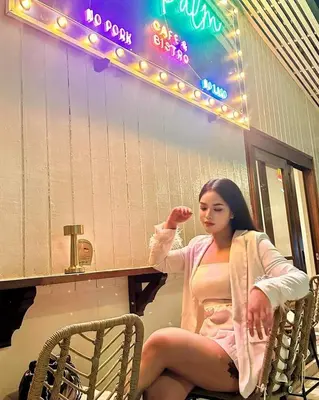 a woman sitting at a table in front of a mirror at The Palm Suite Tanjung Tokong in George Town