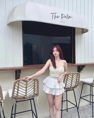 a woman in a white dress standing next to chairs at The Palm Suite Tanjung Tokong in George Town