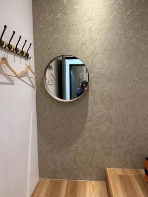a person taking a picture of a mirror on a wall at Adik Aisyah Muji Homestay Cameron Highlands N in Cameron Highlands