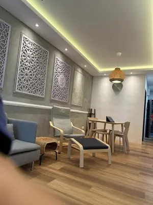 a living room with chairs and tables and a table at Adik Aisyah Muji Homestay Cameron Highlands N in Cameron Highlands