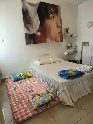 a bedroom with a bed and a painting on the wall at perdana homestay in Ipoh