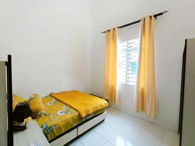 a small bedroom with a bed and a window at Manjung Point Homestay in Seri Manjung
