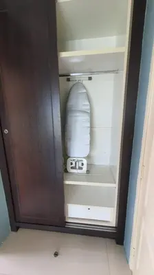 a wooden cupboard with a bottle and a clock in it at Sky Residence -3 Bedrooms Condo at Cinta Sayang, Sungai Petani in Sungai Petani