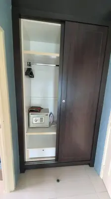 a wooden cabinet with a microwave in a room at Sky Residence -3 Bedrooms Condo at Cinta Sayang, Sungai Petani in Sungai Petani