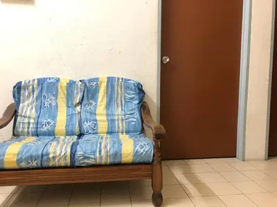 a blue and yellow couch sitting in a room at CLP Perai Homestay Apartment in Chai Leng park in Perai