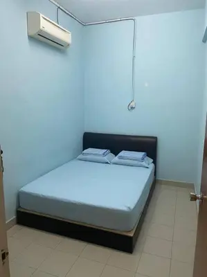 a bed in a room with a blue wall at CLP Perai Homestay Apartment in Chai Leng park in Perai