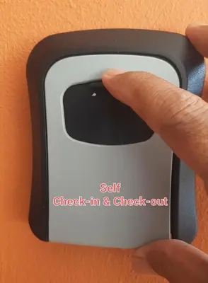 a person holding a smart phone with their finger at FJ Homestay in Seri Iskandar