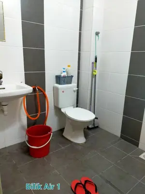 a bathroom with a toilet and a sink and a bucket at FJ Homestay in Seri Iskandar