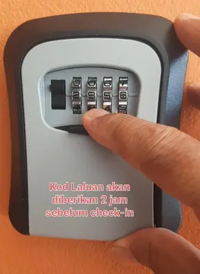 a person pressing a button on a remote control at FJ Homestay in Seri Iskandar