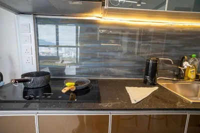 a kitchen counter with a stove and a sink at Seaview Urban suites Georgetown @Penang in Jelutong