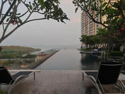 a view of a river with two chairs and a building at Seaview Urban suites Georgetown @Penang in Jelutong