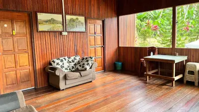 a living room with a chair and a table at Country house Pulai Holiday Village in Gua Musang