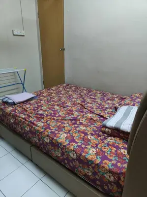 a bed with a floral comforter in a room at HomeStay Pulai in Ipoh