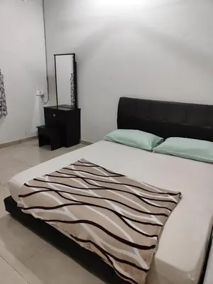 a bedroom with a bed with a black headboard and a mirror at Casa Margosa Homestay in Ipoh