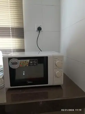 a white microwave sitting on top of a counter at Casa Margosa Homestay in Ipoh