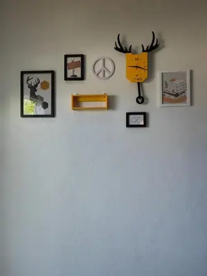 a wall with pictures and a clock on it at Padang Serai Cozy Roomstay Share Bathroom in Padang Serai