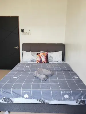 a bed with two cats on the pillows on it at Padang Serai Cozy Roomstay Share Bathroom in Padang Serai