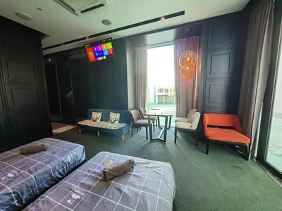 a hotel room with two beds and a table and chairs at Maritime Cozy Suite @ Penang Georgetown in Jelutong