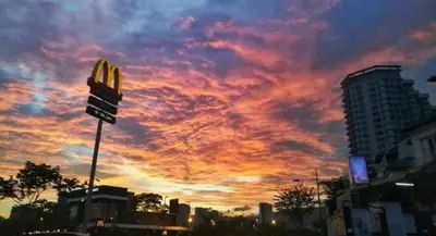 a cloudy sky with a mcdonalds sign and a sunset at Maritime Cozy Suite @ Penang Georgetown in Jelutong