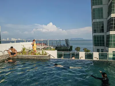 a group of people swimming in a swimming pool on a building at Maritime Cozy Suite @ Penang Georgetown in Jelutong