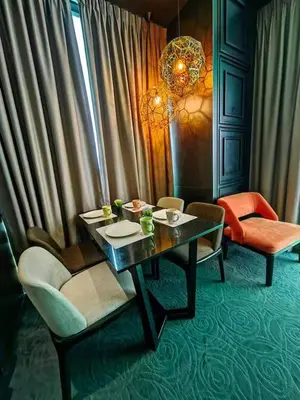 a dining room with a table and chairs and a chandelier at Maritime Cozy Suite @ Penang Georgetown in Jelutong